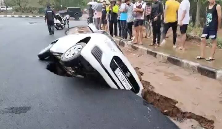 A road collapsed during the rain, causing a car to get stuck in the Ahmedabad district of Gujarat. (Image source: X/@DrJain21)