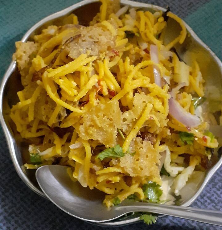 தேவையான பொருட்கள் : நூடுல்ஸ் - 200 கிராம் , நறுக்கிய பெரிய வெங்காயம் - 1, துருவிய கேரட் - 1, துருவிய முட்டை கோஸ் - 1 கப், எலுமிச்சை சாறு - 1 மேசைக்கரண்டி , நல்லெண்ணெய் - 2 தேக்கரண்டி , புளிச்சாறு - 1 மேசைக்கரண்டி, பூண்டு, எண்ணெய், கேசரி பொடி , வரமிளகாய் பிளேக்ஸ் , உப்பு, தண்ணீர், தட்டு வடை, கொத்தமல்லி இலை, உப்பு கலந்த தண்ணீர்