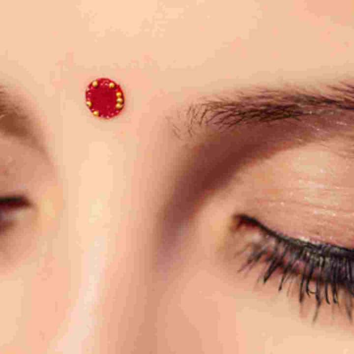 People with round faces should wear vertically shaped bindi. If your face is round, then do not wear a very big round bindi. This will make your face look very fat and round. You can put a small round bindi there.