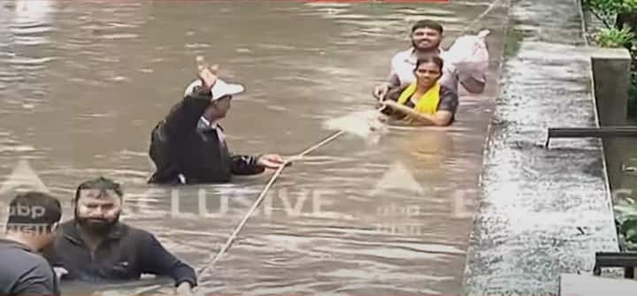 लोक जीवाचा आटापिटा करत पाण्यातून मार्ग काढत आहेत.