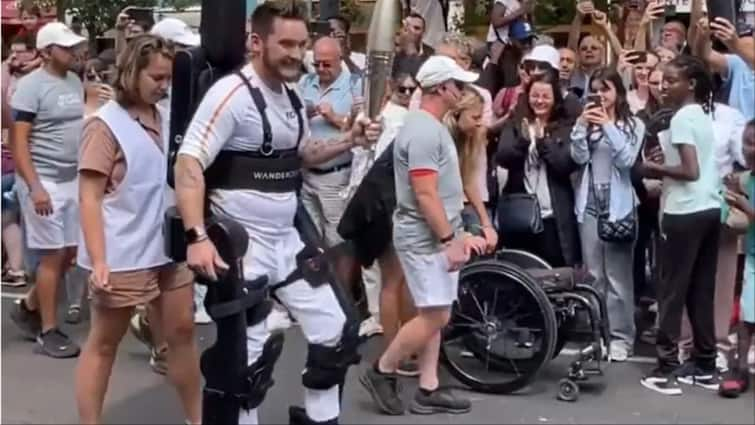 Paraplegic Tennis Player Kevin Piette In Robotic Exoskeleton Carries Olympic Torch Video Goes Viral Video: पेरिस ओलंपिक में लोगों ने देखा गजब नजारा! जानिए दिव्यांग एथलीट टॉर्च लेकर सड़क पर कैसे चला?