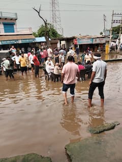 गुरुग्राम के बिलासपुर रोड पर पानी में कुर्सी डालकर बैठे दुकानदार, प्रशासन पर लगाया ये आरोप