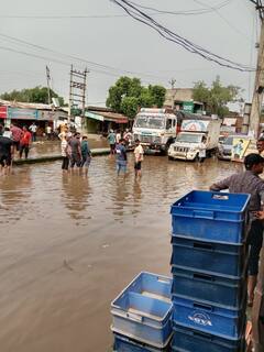 गुरुग्राम के बिलासपुर रोड पर पानी में कुर्सी डालकर बैठे दुकानदार, प्रशासन पर लगाया ये आरोप
