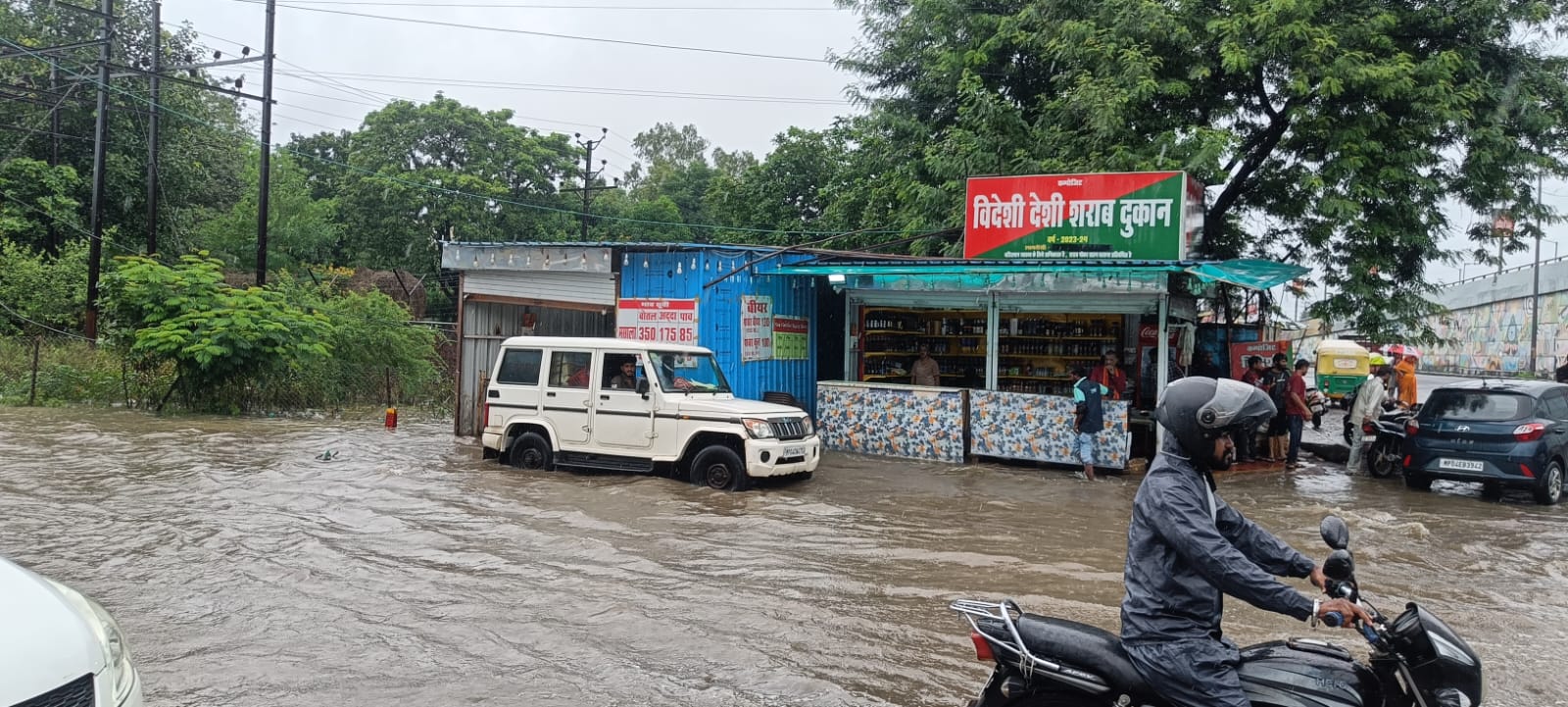 Watch: भोपाल में भारी बारिश में भी खुद को नहीं रोक पाए शराब के शौकीन, जलभराव के बीच पहुंच रहे दुकान