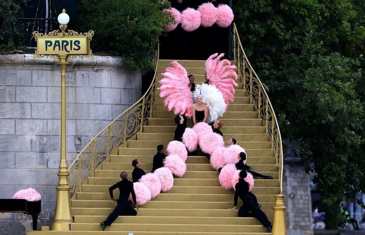 She first appeared in a big black ostrich feather coat before stepping out of a crowd of pink ostrich feather.