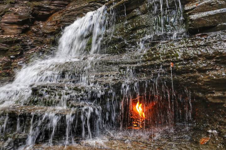 हम न्यूयॉर्क में मौजूद इटरनल फ्लेम फॉल्स की बात कर रहे हैं. इस झरने के पीछे लगातार आग जलती रहती है, जिसके चलते इसे रहस्यमयी माना जाता है.