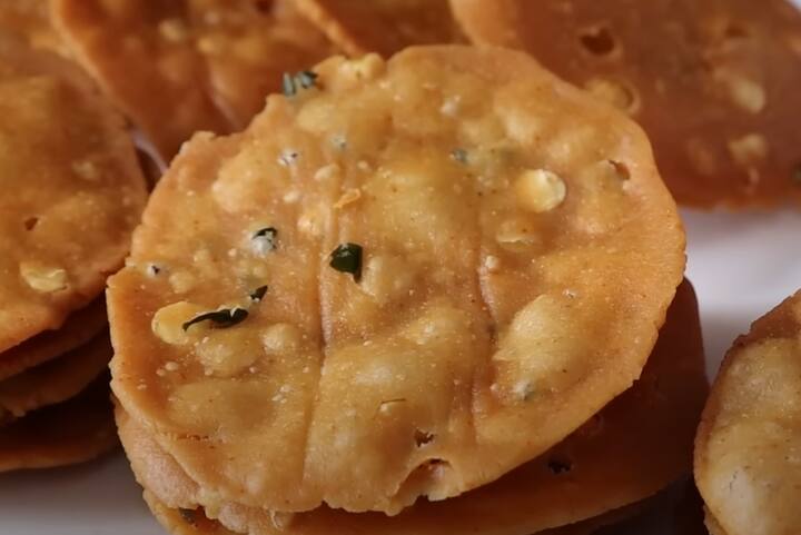 ஒரு பெரிய பாத்திரத்தில் அரிசி மாவு, ஊறவைத்த கடலை பருப்பு சேர்க்கவும். அத்துடன் அரைத்த மசாலா உப்பு, மஞ்சள் தூள், காஷ்மீரி சிவப்பு மிளகாய் தூள், சீரகம், எள், பெருங்காய தூள் மற்றும் உப்பில்லாத வெண்ணெய் சேர்க்கவும்.