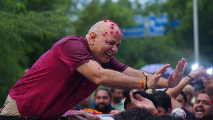 As Sisodia walked out of jail he was greeted by party workers and leaders who braved the rain and had gathered there to welcome him. They showered rose petals on him as he walked out of jail. (Image source: AAP)