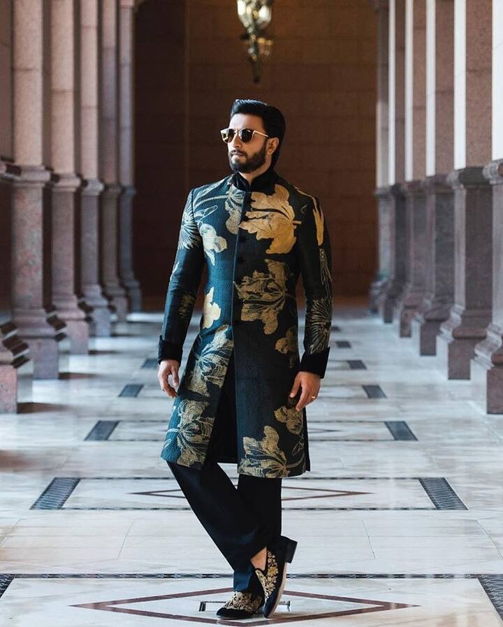 Ranveer captivates us in this green kurta adorned with golden flowers. Wearing sunglasses and studded juttis, he completes the outfit.