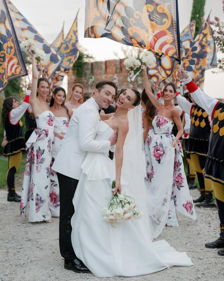 At sunset, Amy stood in front of a huge flower arch, holding a lovely bouquet of white roses.