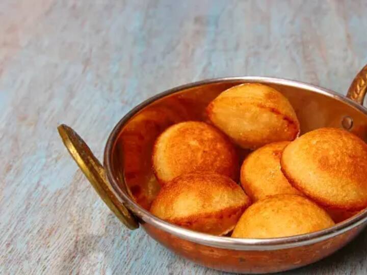 எண்ணெய் காய்ந்ததும், சர்க்கரை மற்றும் அன்னாசி பழத்தை ஒவ்வொரு குழியிலும் சேர்த்து வேகவிடவும்.