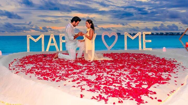 ছবিগুলিতে আদরকে দেখা গেল সাদা ও নীল স্ট্রাইপ শার্ট আর প্যান্ট পরে। হাঁটু মুড়ে বসে প্রেমিকার হাত ধরে তাঁর সঙ্গে বাকি জীবন একসঙ্গে কাটানোর প্রস্তাব দিলেন।