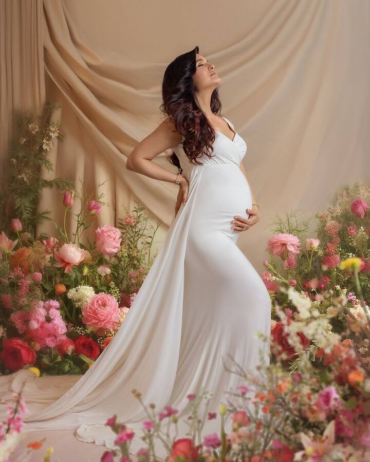 For the first set, she wore a stunning white gown with a thigh-high slit, posing against a dreamy backdrop of pink flowers.