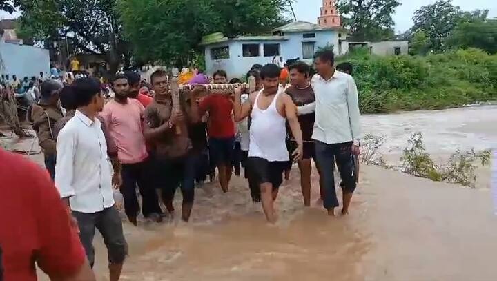 गावकऱ्यांनी एक खाट आणली आणि त्या खाटेवर महिलेला झोपवलं. ती खाट खांद्यावर घेऊन गावकऱ्यांनी पूर आलेल्या ओढ्यातून पायी प्रवास करत महिलेला रुग्णालयात पोहोचवलं.