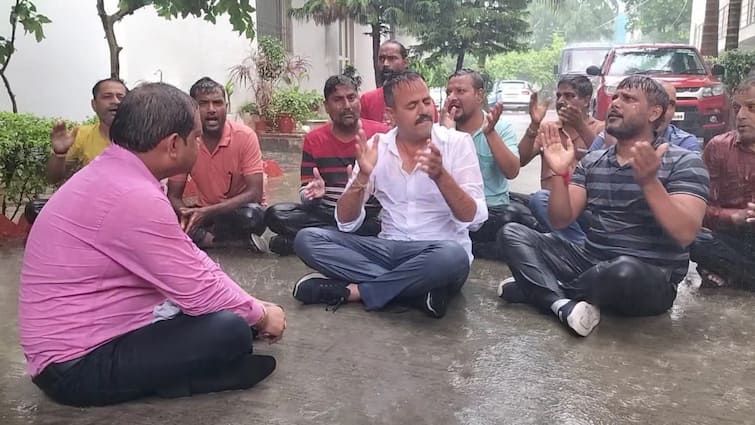 Meerut unique protest against electricity department in rain ann मेरठ बिजली विभाग पर फूटा लोगों का गुस्सा, अफसरों को बारिश में धरने पर बिठाया, दिया 24 घंटे का अल्टीमेटम