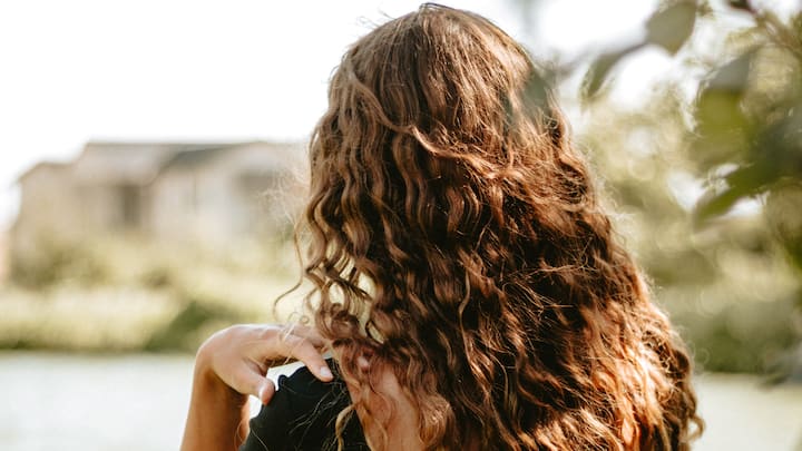 4. Opt for soft curls: If you want a more contemporary look, soft waves or loose curls are a great option. You can achieve this with a curling iron or by using heatless methods like braiding damp hair overnight. This style works well with both traditional and modern outfits and adds volume and texture to your hair. (Image source: Canva)