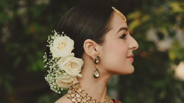 2. Go for traditional styles: Ganesh Chaturthi is synonymous with tradition, and what better way to celebrate it than with a classic bun or braid? A simple yet elegant bun can be paired with traditional flowers like jasmine or rose petals to give it a festive look. Alternatively, opt for a herringbone braid or a traditional three-strand braid, which will keep you looking stylish and comfortable all day long. (Image Source: Pinterest/ BollywoodShaadis.com)