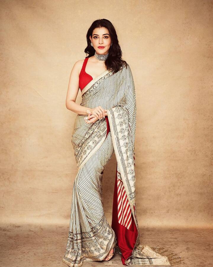 సిల్క్ చీరకట్టుకుని ఫోటోలకు ఫోజులిచ్చింది కాజల్. క్రీమ్, బ్లాక్ కలర్ కాంబినేషన్లో వచ్చిన ఈ చీరను రెడ్ కలర్ బ్లౌజ్తో సెట్ చేసుకుంది కాజల్. (Images Source : Instagram/Kajal Agarwal)