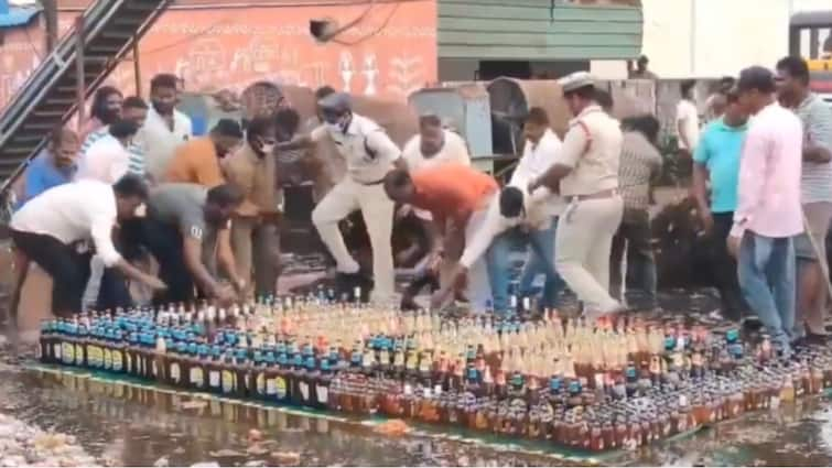 Andhra Cops Line Up Seized Bottles Of Liquor Worth Rs 50L For Disposal, Locals Run Away With Them WATCH WATCH: Andhra Cops Line Up Seized Bottles Of Liquor Worth Rs 50L For Disposal, Locals Run Away With Them