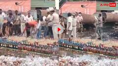 पुलिस के सामने शराब की खुली लूट, बुलडोजर चलने से पहले सड़क से बोतलें उड़ा ले गए लोग