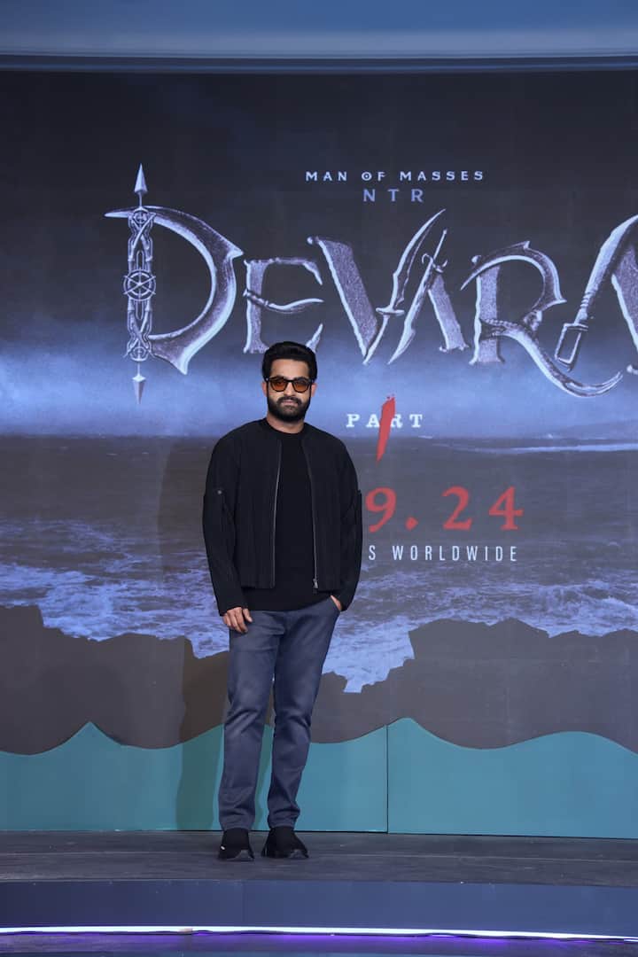 ‘देवरा’ ट्रेलर लॉन्च इवेंट में जूनियर एनटीआर काफी हैंडसम लुक में दिखे. उन्होंने ब्लैक टीशर्ट के साथ ब्लू डेनिम और उसके साथ ब्लैक जैकेट कैरी की थी.