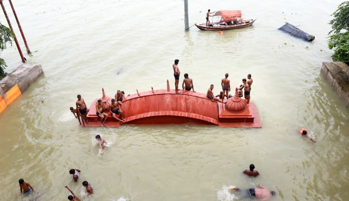 People bathe in Ganga floodwaters following heavy rains, in Prayagraj. Chief Minister Yogi Adityanath has given instructions to deploy NDRF, SDRF and other rescue teams as per requirement in the flood-affected areas. (Photo: PTI)