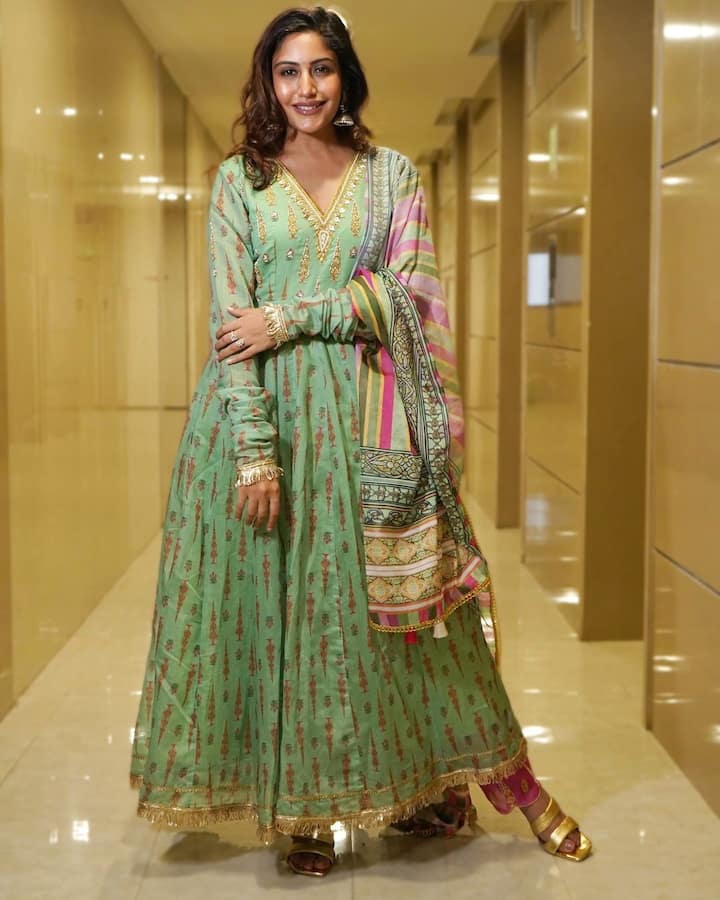 In the snapshots, Surbhi looked elegant in a long-sleeved green ethnic Anarkali suit paired with a magenta pink palazzo.