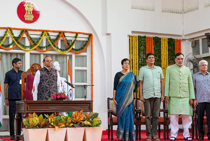 Delhi Lt. Governor V.K. Saxena with CM Atishi, and AAP leaders Saurabh Bharadwaj, Gopal Rai, Kailash Gahlot, Imran Hussain and Mukesh Ahlawat during her swearing-in ceremony, at Raj Niwas, in New Delhi, Saturday, Sept. 21, 2024. (PTI Photo)