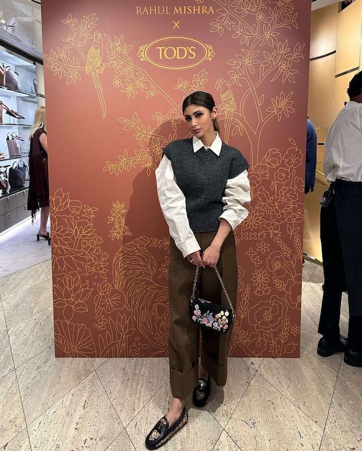 Mouni Roy's street-style look featured brown formal pants paired with a crisp white shirt and a woollen vest.