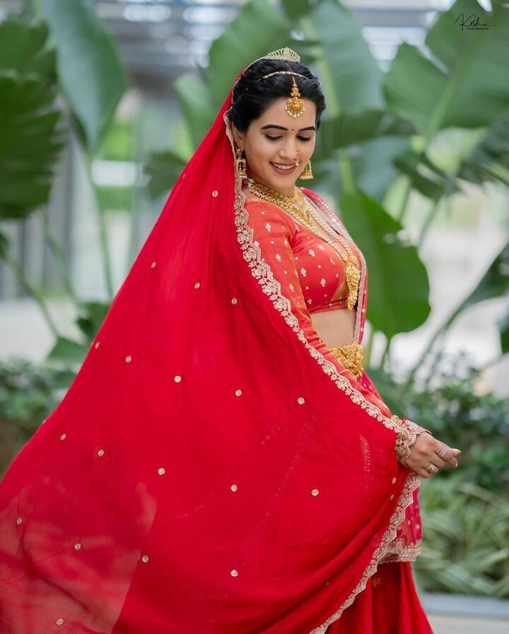 రెడ్ లెహంగా, జాకెట్, దుపట్టాలో స్రవంతి చాలా అందంగా కనిపించింది. గోల్డెన్ జ్యూవెలరీతో అందంగా ముస్తాబైంది. (Images Source : Instagram/Sravanthi Chokarapu)