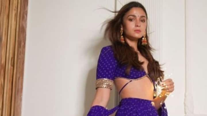 3. The blouse is a bold, deep-plunge style with intricate gold detailing on the borders, adding an elegant touch to the vibrant purple hue. (Image Source: Pinterest/KollyBollyShop)