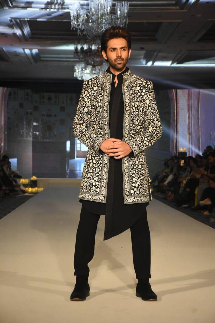 इस दौरान कार्तिक आर्यन का लुक भी काफी डैशिंग रहा. ब्लैक शेरवानी के साथ व्हाइट वर्क वाला कोट पहने एक्टर ने मनीष मल्होत्रा के लिए रैंप वॉक किया.