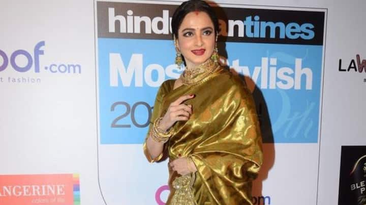 3. Stunning Golden Saree: Rekha stuns in a gold silk saree in this look. She has complemented her look by traditional jewellery, sleek hair, and her signature bold makeup, showcasing her iconic elegance and poise. (Image Source: Pinterest/fashionprome)