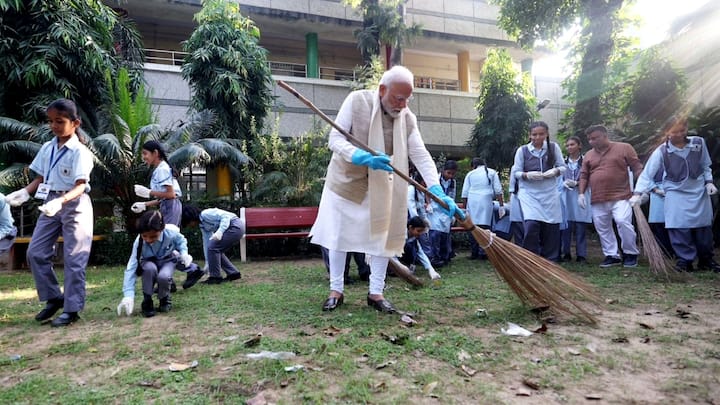 Gandhi Jayanti: गांधी जयंती पर पीएम मोदी ने स्कली बच्चों के साथ झाड़ू लगाया. उन्होंने कहा कि अगर सभी देशवासी स्वच्छता का महत्व समझेंगे तो स्वच्छ भारत की भावना मजबूत होगी.