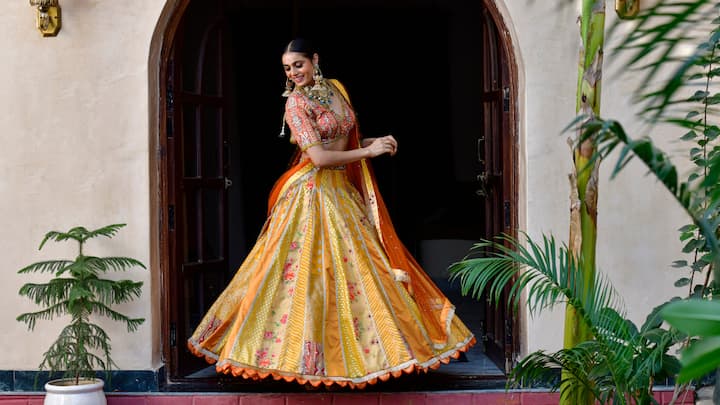 Lehenga Choli: A lehenga choli, with its elaboratie embroidery, mirror work, and striking designs, can bring a touch of regal elegance to your Navaratri look. Pairing it with traditional jewellary like kundan earrings and a maang tikka will enhance the overall elegance. (Image source: Canva)