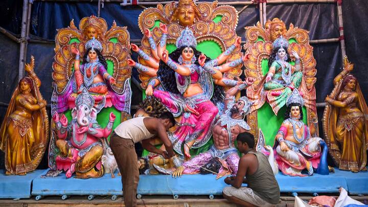 Artisans give final touches to an idol of Goddess Durga ahead of Durga Puja, at Balurghat in Dakshin Dinajpur district. (Photo: PTI)