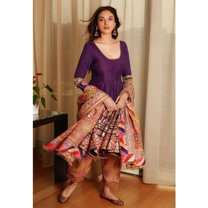 This elegant purple ensemble perfectly complement her beauty with a deep neckline that accentuates her collarbone. The traditional dupatta, adorned with intricate embroidery, showcases mesmerizing zari and kundan work, adding a luxurious touch to the overall look.