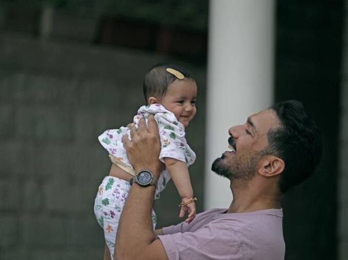 In this picture, Abhinav is looking very happy holding one of his two daughters in his lap.