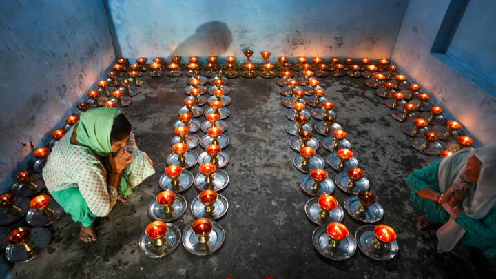 Two women light lamps at the Baba Sidh Goria temple during Navratri celebrations, in Jammu. (Photo: PTI)