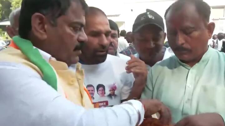 Congress leader Jagdish Sharma distributes laddoos at AICC headquarters in Delhi as the party took the lead in early trends in Haryana and J&K. (Photo: ANI)