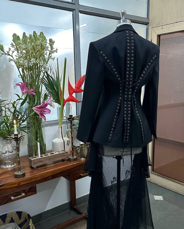 The blazer featured crisp notch lapels, hard shoulders and decorative metal buckles in the back.