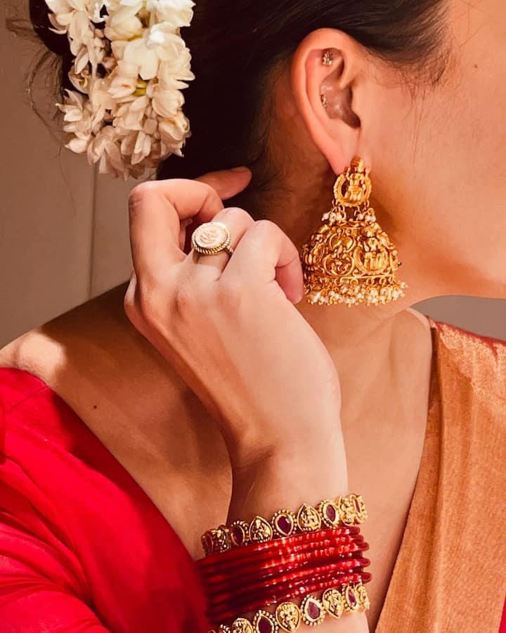 इस तस्वीर में एक्ट्रेस अपने कानों में गोल्ड के झुमके फ्लॉन्ट करती हुई दिख रही हैं. उन्होंने हाथों में लाल रंग की चूड़ियों के साथ गोल्ड के कंगन भी पहने हुए हैं.