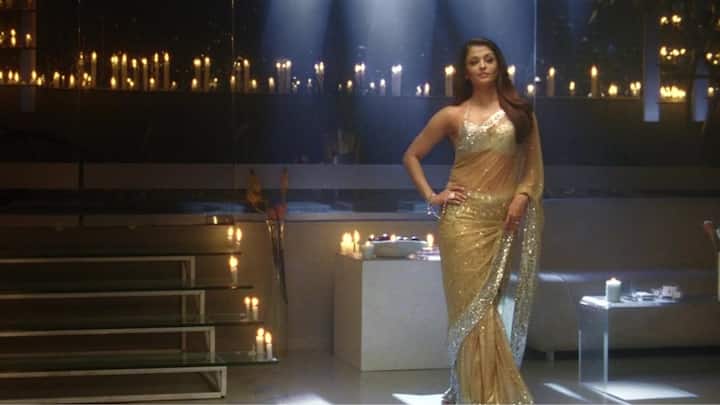 Golden Saree in Robot: Aishwarya’s sultry Golden net shimmer saree from Robot offers the perfect fusion of traditional and edgy fashion. The daring combination of a golden saree with a modern twist will certainly turn heads during a Garba night, making it a fashion-forward choice. (Image source: IMDb)