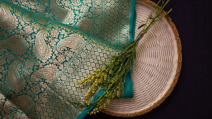 1. Saree Or Lehenga: On this auspicious festival of Karwa Chauth, women enjoy dressing up, and a stunning designer saree or lehenga makes for an ideal gift for your wife. Choose fabrics like silk, chiffon, or velvet in traditional shades such as red, maroon, or gold, which are symbolic of the festival.  (Image source: Canva)