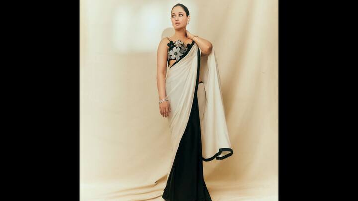 5. Black And White Saree: The ideal choice for the Diwali celebrations is Tamannaah's black and white satin saree. The saree features a sophisticated black border. Tamannaah's blouse, which has been styled to seem like flowers, contains lovely beadwork. The understated yet sophisticated black and white saree looks stunning with the elaborate beading on the blouse. Minimal pearl flower earrings complete Tamannaah's attire. (Image Source: Instagram/@tamannaahspeaks)