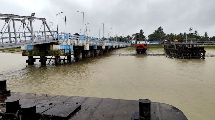 কাকদ্বীপে বন্ধ রয়েছে ফেরি চলাচল। আকাশে কালো মেঘের ঘনঘটা। মাঝে মধ্যেই বৃষ্টি হচ্ছে। লোহার চেন দিয়ে বেঁধে রাখা হয়েছে নৌকা। যেকোনও রকম পরিস্থিতির মোকাবিলায় প্রস্তুত রয়েছে প্রশাসনও।