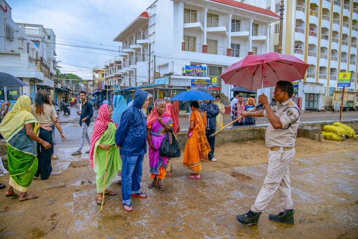 A police personnel asks visitors to vacate the beach in view of cyclone 'Dana' which is expected to make landfall in Odisha, in Puri, Thursday, Oct 24, 2024. (Image Source: PTI)