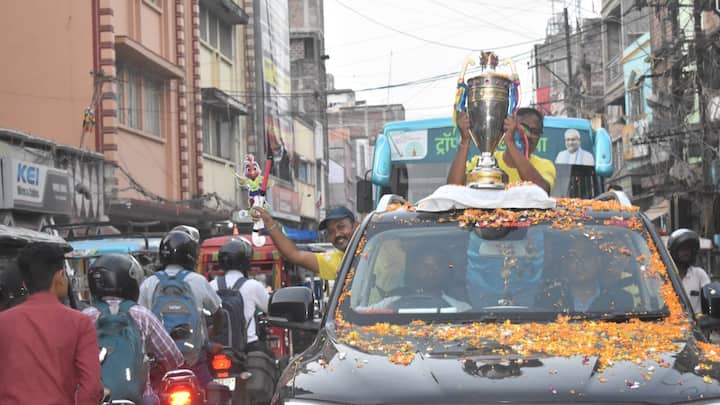 One of the event's highlights was the ceremonial passing of the ball, a symbolic gesture marking the journey of the championship trophy through the districts. Following this, the trophy embarked on a grand roadshow through the city, with crowds lining the streets. In an awe-inspiring display of joy and reverence, people showered flowers as the procession passed by, filling the roads with color and cheer.