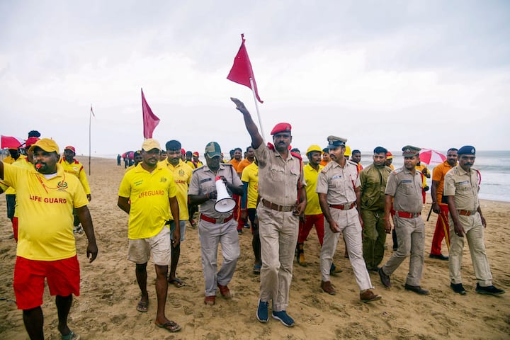 Police personnel with a team of lifeguards make announcements to prevent tourists from visiting the beach in view of cyclone 'Dana' which is expected to make landfall in Odisha, in Puri, Thursday, Oct 24, 2024. (Image Source: PTI)