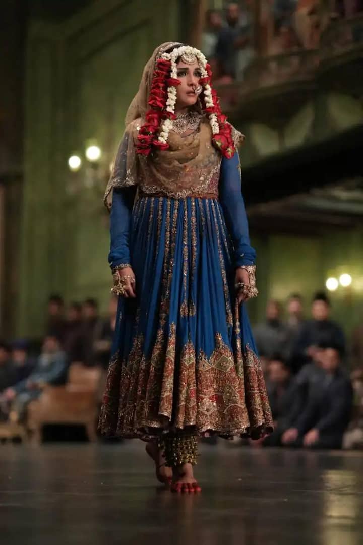 'रिचा चड्ढा' ने राजसी नीले रंग का आउटफिट पहना, जो उनके किरदार लज्जो को जीवंत करता है. उनके फ्लोरल मांग टीका और ग्लैमरस ज्वेलरी ने इस लुक को जादुई बना दिया.